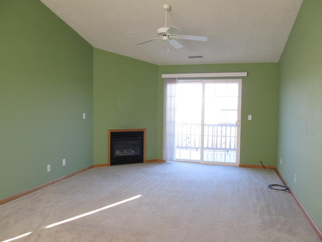 983 Kelly Lane, Unit 983 Sycamore, IL 60178 - Photo 12 of 25 an empty room with windows and fireplace