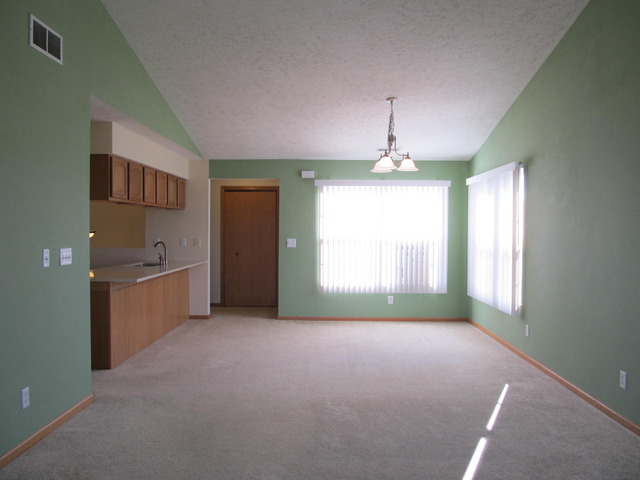 983 Kelly Lane, Unit 983 Sycamore, IL 60178 - Photo 13 of 25 a big room with windows and chandelier