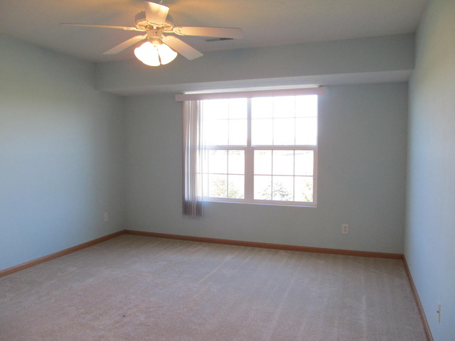 983 Kelly Lane, Unit 983 Sycamore, IL 60178 - Photo 15 of 25 an empty room with a window and a fan