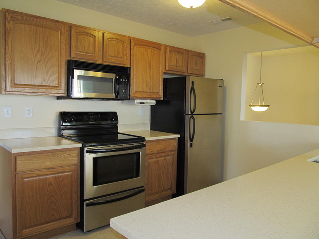 983 Kelly Lane, Unit 983 Sycamore, IL 60178 - Photo 5 of 25 a kitchen with a refrigerator stove and microwave