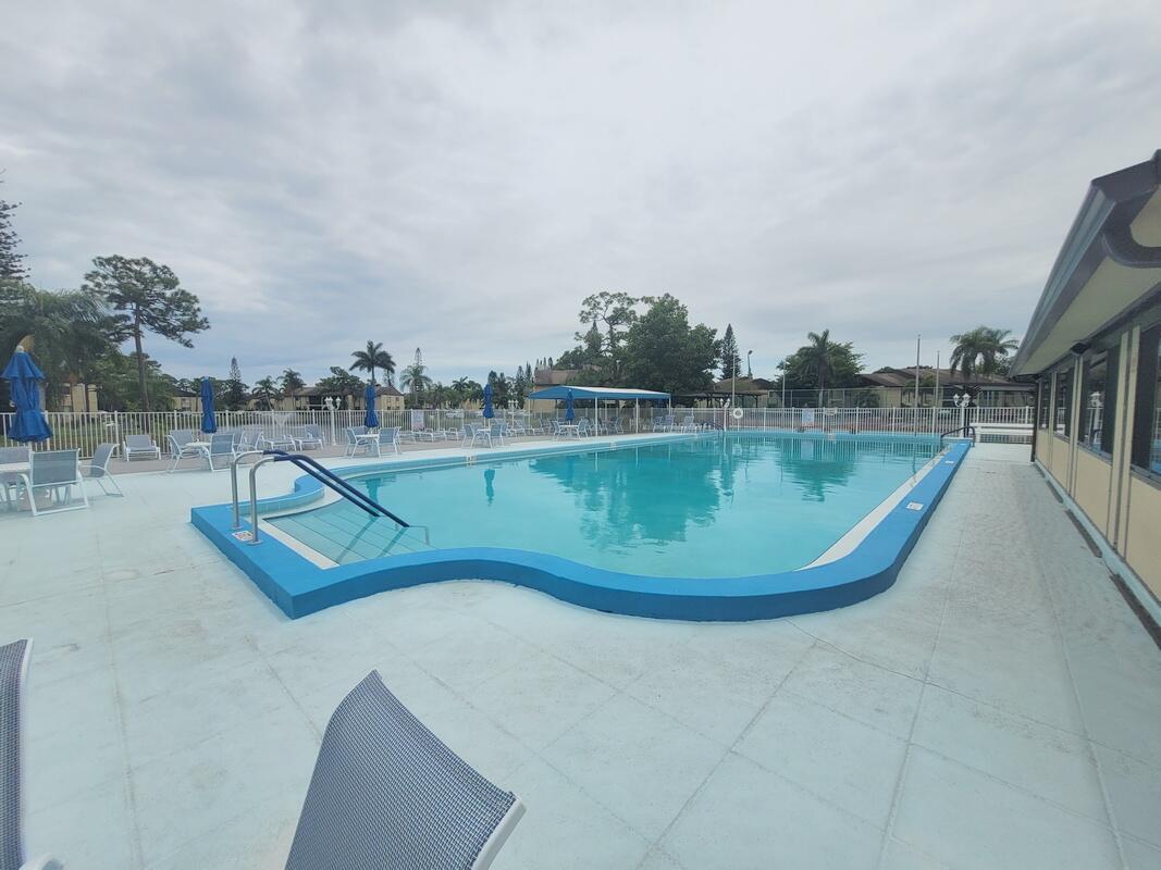 320 Pine Ridge Circle, Unit A1 Greenacres, FL 33463 - Photo 27 of 65 a view of a swimming pool with an outdoor seating