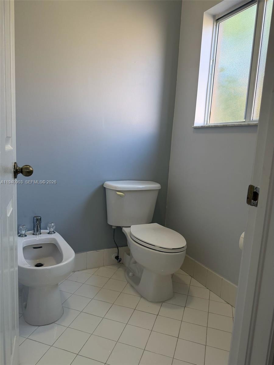 22547 Southwest 94th Path, Unit 22547 Cutler Bay, FL 33190 - Photo 12 of 20 a white toilet sitting next to a bathroom sink