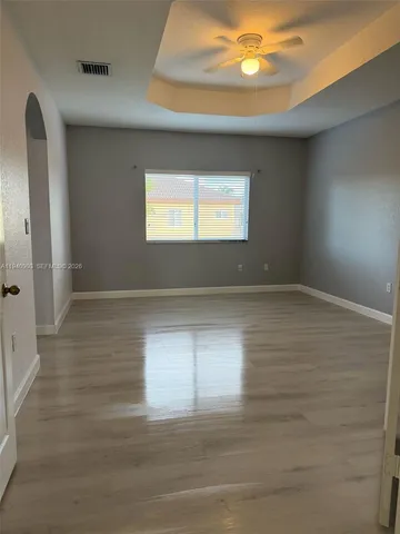 a view of empty room with window and wooden floor