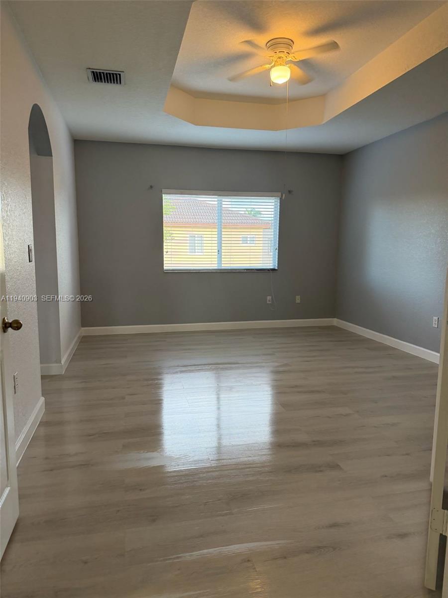 22547 Southwest 94th Path, Unit 22547 Cutler Bay, FL 33190 - Photo 10 of 20 a view of empty room with window and wooden floor