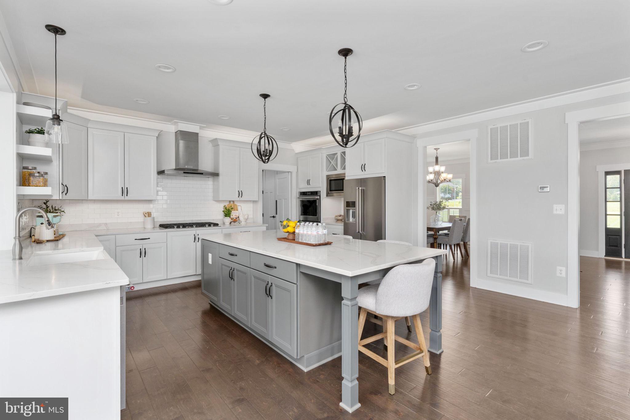115 Saddle Ridge Lane Fredericksburg, VA 22406 - Photo 29 of 100 a kitchen with stainless steel appliances kitchen island granite countertop a sink a table and chairs in it