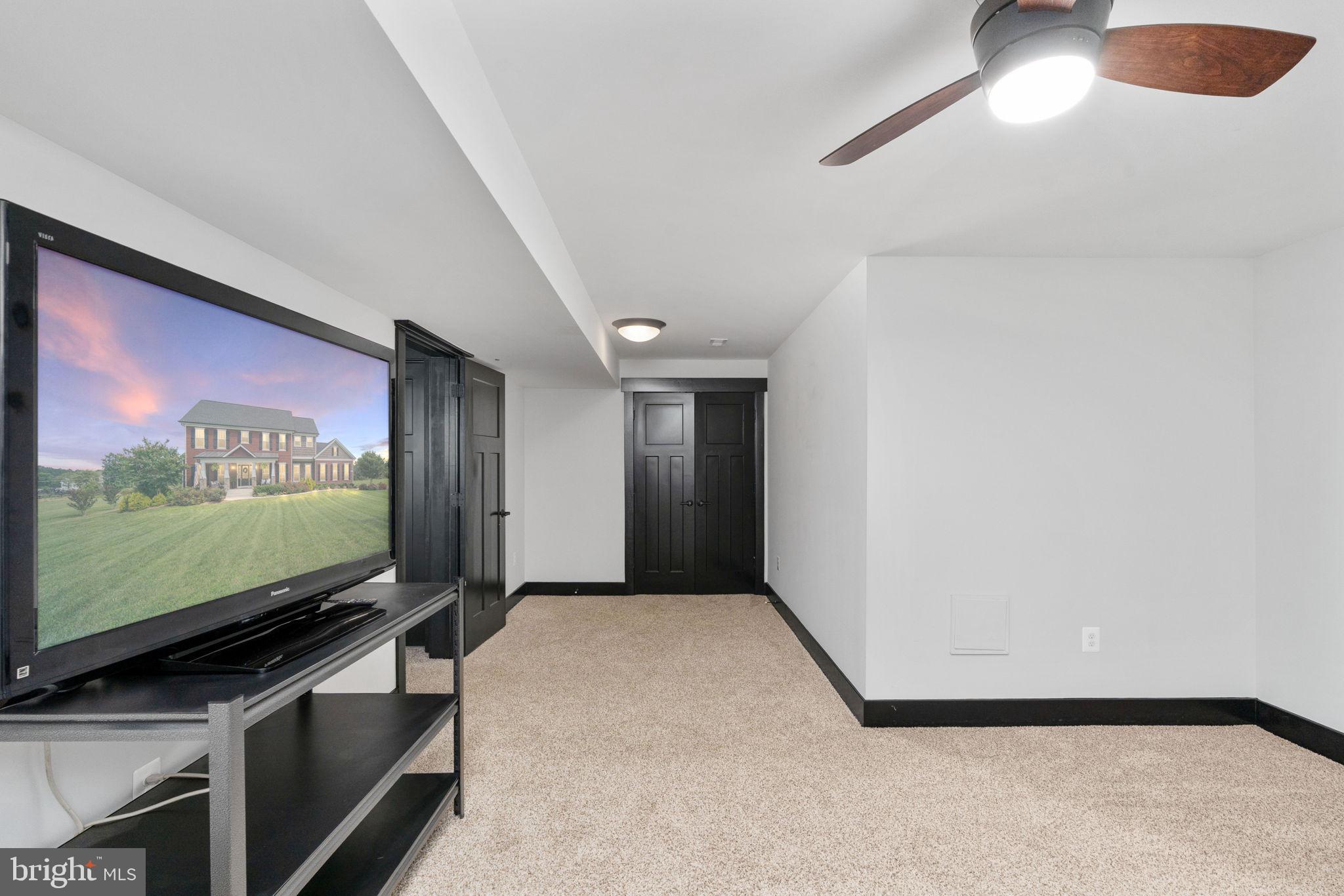 115 Saddle Ridge Lane Fredericksburg, VA 22406 - Photo 83 of 100 a living room with projector and a flat screen tv