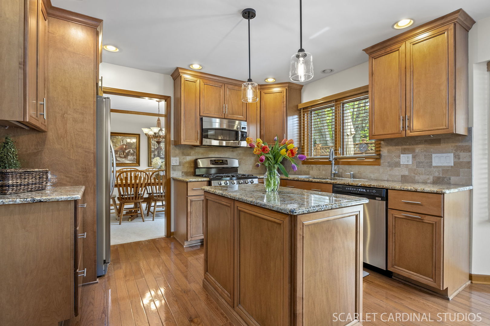 2565 Thornley Court Aurora, IL 60504 - Photo 6 of 59 a kitchen with stainless steel appliances granite countertop a stove a sink dishwasher a refrigerator and a dining table with wooden floor
