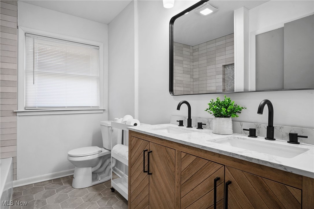 15857 Henley Road Cleveland, OH 44112 - Photo 22 of 42 Bathroom featuring vanity, toilet, tile patterned floors, and a shower