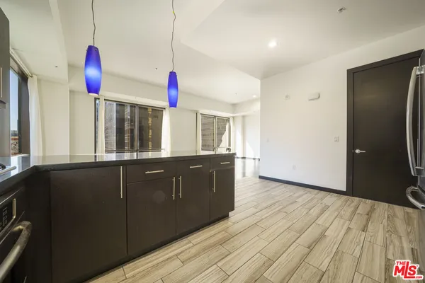 a kitchen with granite countertop a stove a sink and a refrigerator