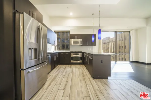 a kitchen with stainless steel appliances granite countertop a refrigerator a sink and a stove