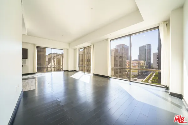 a view of a big room with wooden floor and windows