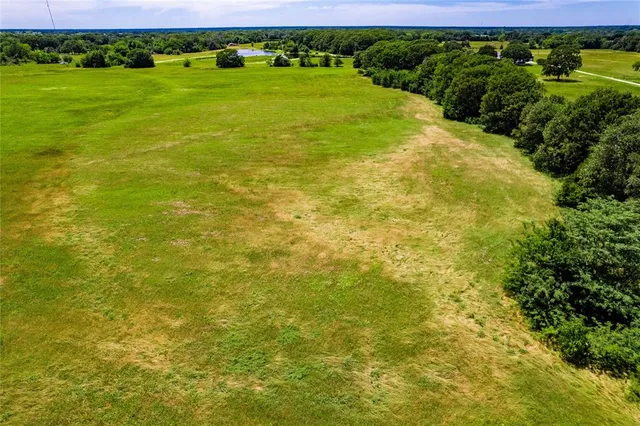 a view of a big yard with lots of green space and bushes