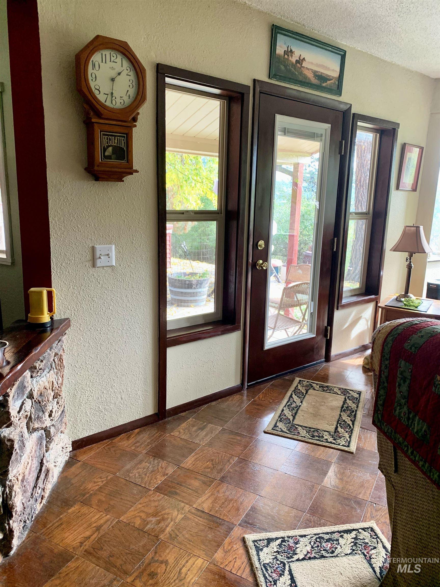 307 Locust Road Kamiah, ID 83536 - Photo 31 of 50 Wood-finish flooring with a square pattern, floor-to-ceiling windows, and a glass-paneled door with dark wood trim