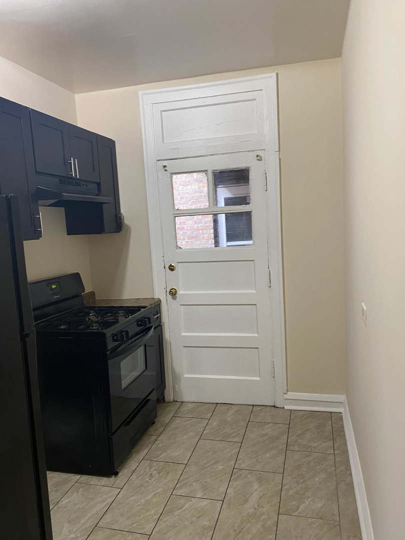 1729 West 91st Street, Unit 2 Chicago, IL 60620 - Photo 3 of 14 a kitchen with a stove and a cabinet