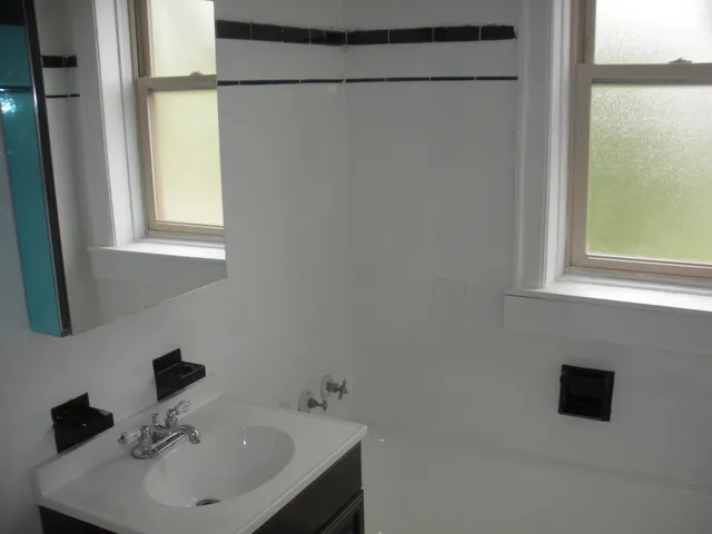 a bathroom with a sink a mirror and a window