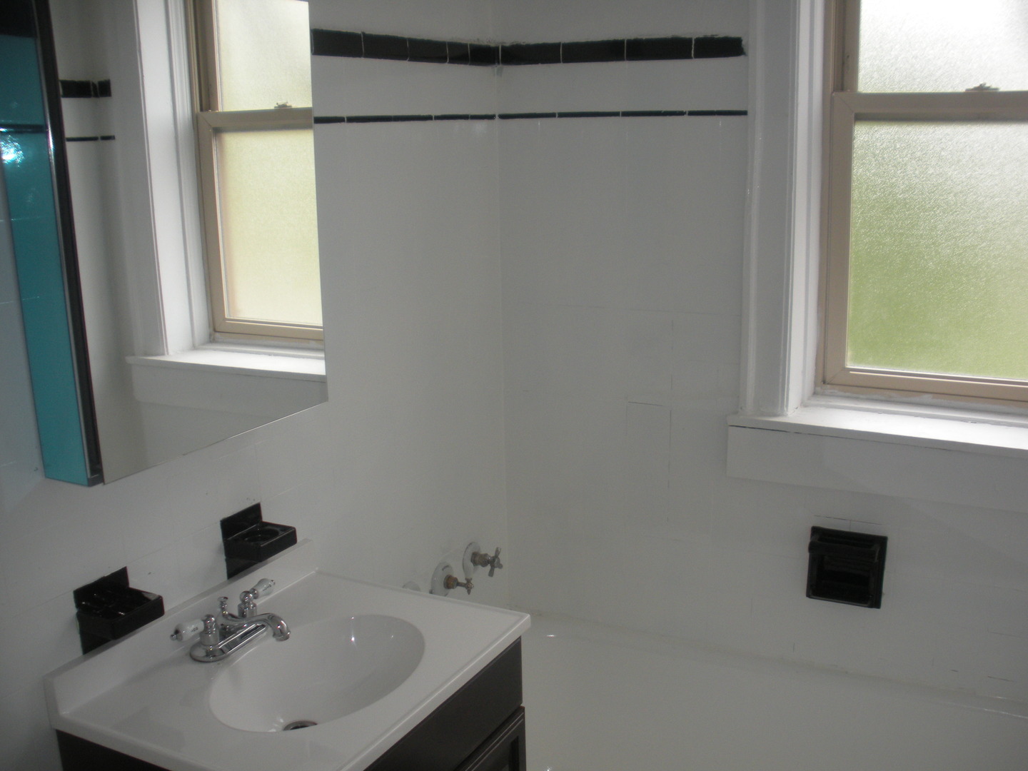 1729 West 91st Street, Unit 2 Chicago, IL 60620 - Photo 10 of 14 a bathroom with a sink a mirror and a window