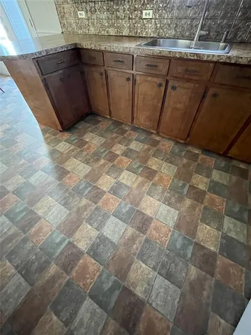 a view of a chairs and table in the back yard of a house