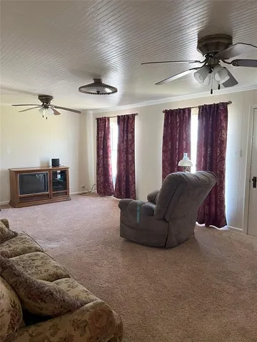 a living room with furniture and a ceiling fan