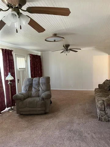 a living room with furniture and a ceiling fan
