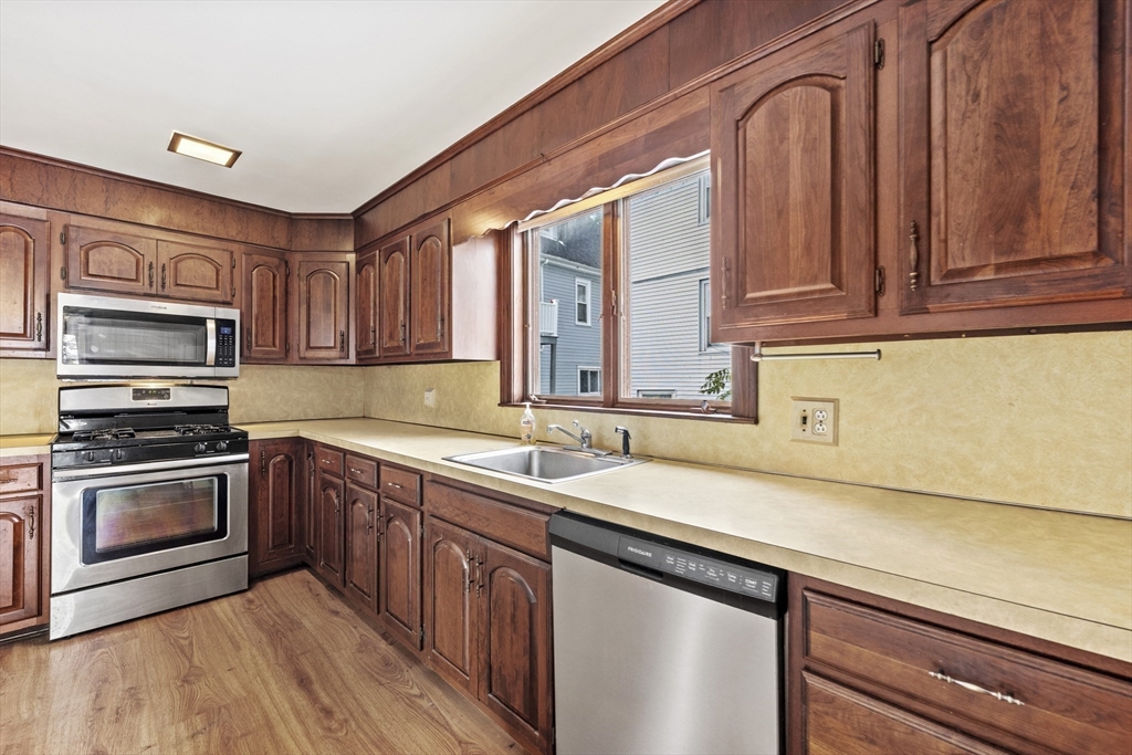 12 Foster Street Everett, MA 02149 - Photo 13 of 29 a kitchen with stainless steel appliances granite countertop a sink and a stove