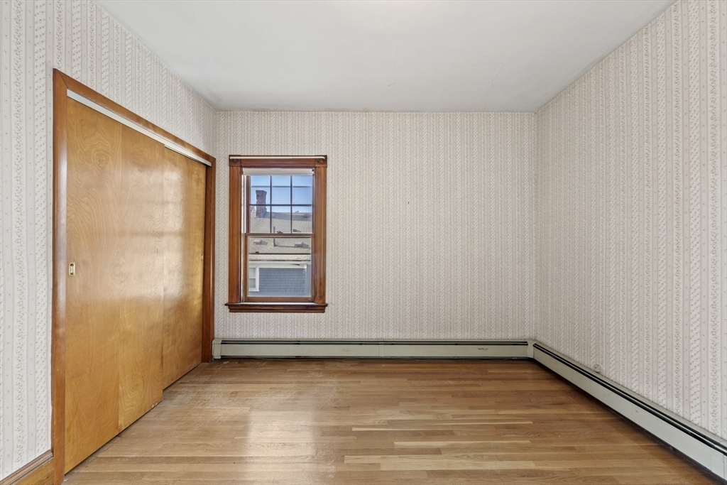 12 Foster Street Everett, MA 02149 - Photo 19 of 29 a view of an empty room with wooden floor and a window