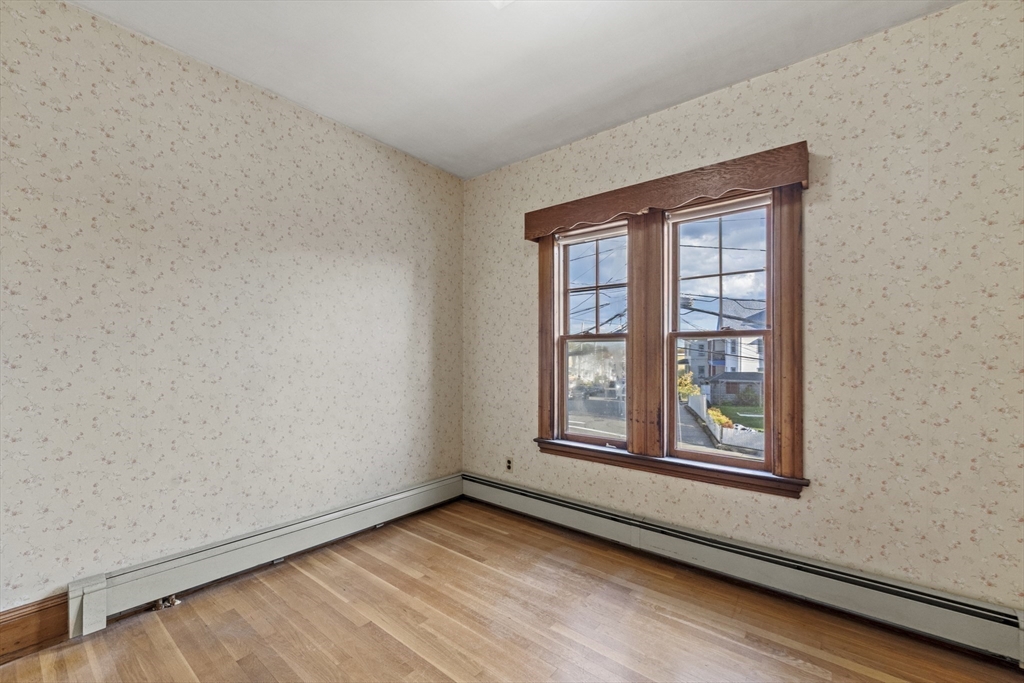 12 Foster Street Everett, MA 02149 - Photo 21 of 29 an empty room with wooden floor and windows