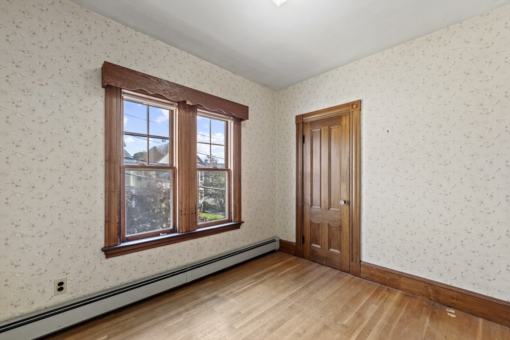 12 Foster Street Everett, MA 02149 - Photo 22 of 29 an empty room with wooden floor and windows