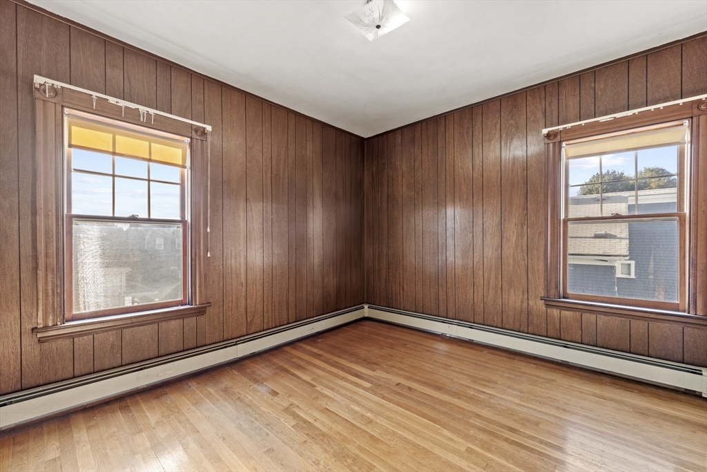 12 Foster Street Everett, MA 02149 - Photo 25 of 29 an empty room with wooden floor and windows