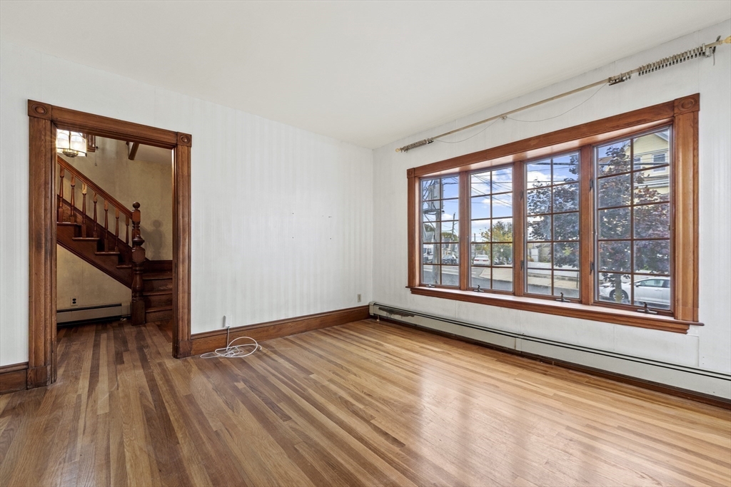 12 Foster Street Everett, MA 02149 - Photo 7 of 29 a view of an empty room with a window and wooden floor