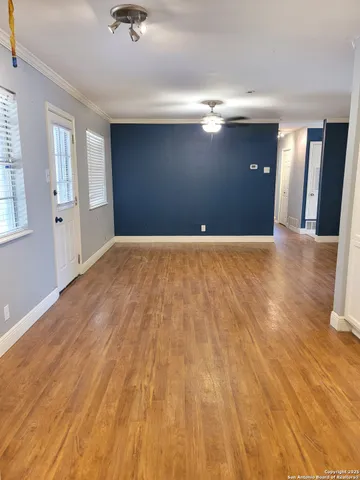 a view of empty room with wooden floor