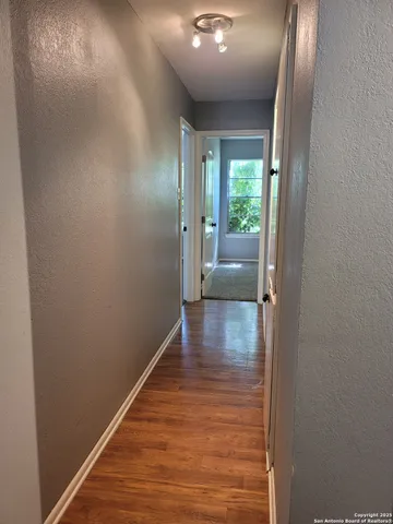 a view of a hallway with wooden floor and staircase