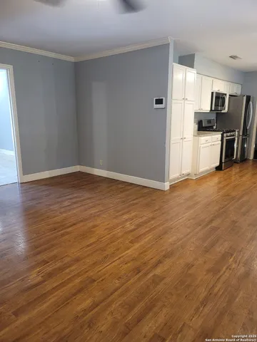 a view of empty room with wooden floor and window