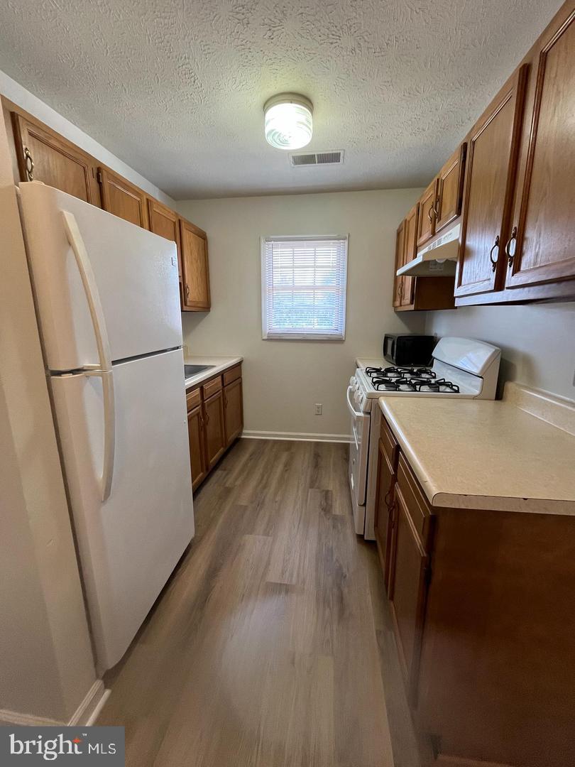 2264 Papermill Road, Unit E Winchester, VA 22601 - Photo 2 of 8 a kitchen with a refrigerator a stove a sink a washer dryer and a refrigerator