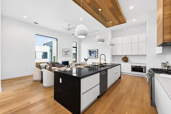 a kitchen with granite countertop a sink a stove and cabinets