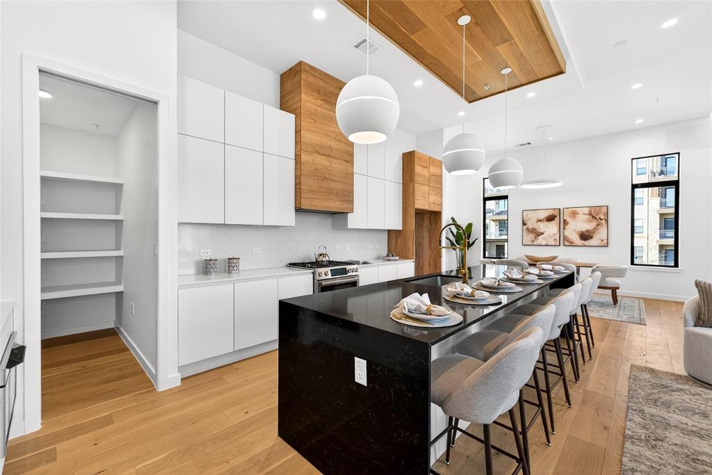 1111 Raiford Road, Unit 112 Carrollton, TX 75007 - Photo 15 of 30 a kitchen with stainless steel appliances granite countertop a stove a sink dishwasher and cabinets with wooden floor