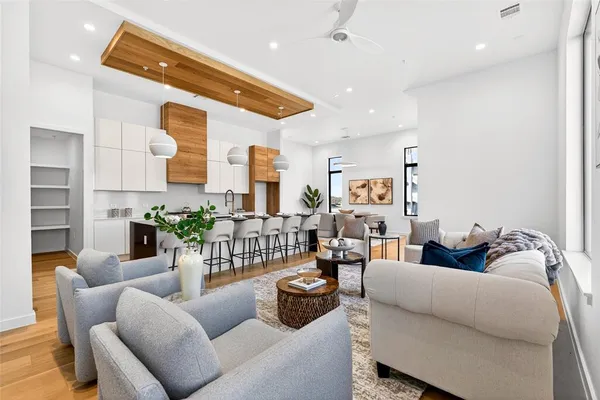 a living room with furniture wooden floor and a large window