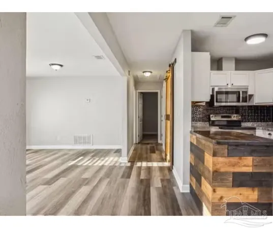 a view of kitchen with sink and refrigerator