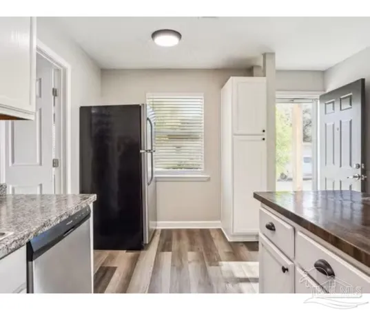 a kitchen with stainless steel appliances granite countertop a refrigerator and a sink