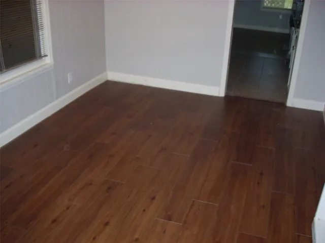 a view of a small space with wooden floor and a window