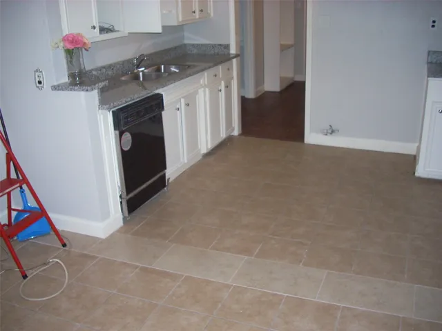 a kitchen with granite countertop a sink and a stove top oven