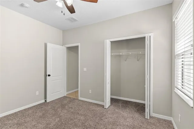 an empty room with windows and closet