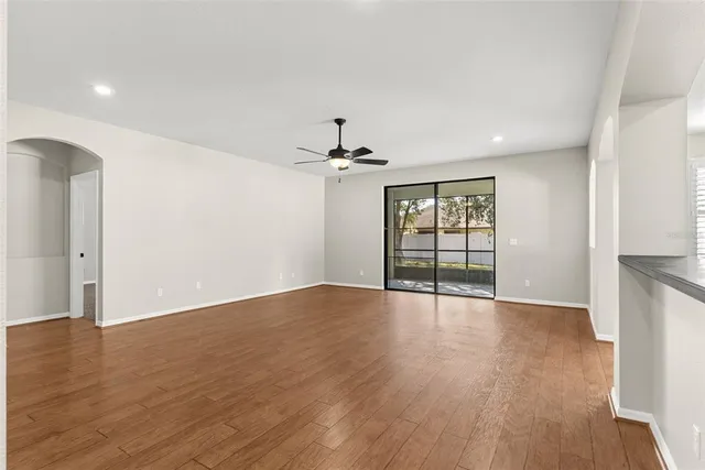 a view of an empty room with a window and wooden floor