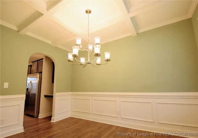 a view of a room with wooden floor and chandelier