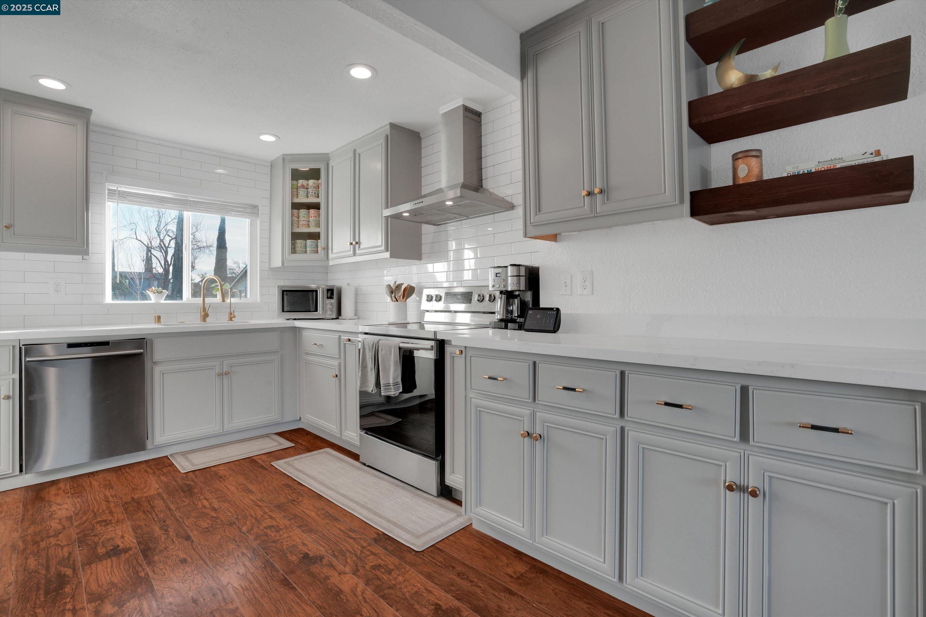 a kitchen with stainless steel appliances granite countertop a sink a stove and cabinets