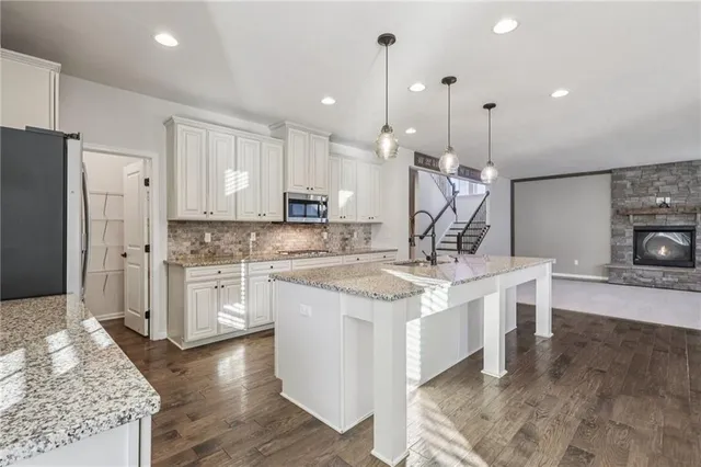 a kitchen with stainless steel appliances granite countertop a sink stove and refrigerator