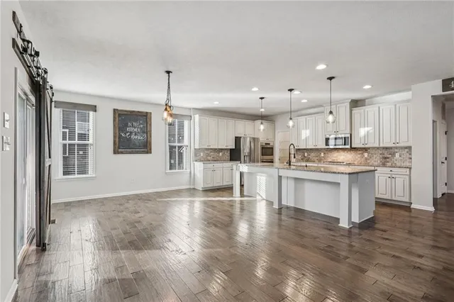 a large kitchen with kitchen island a sink stainless steel appliances and cabinets