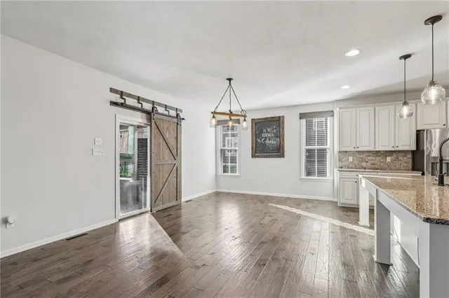 a view of a kitchen with wooden floor and electronic appliances