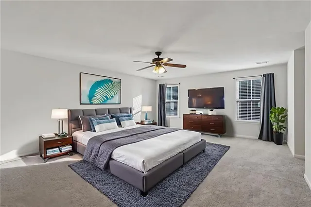 a spacious bedroom with a bed a couch and a chandelier