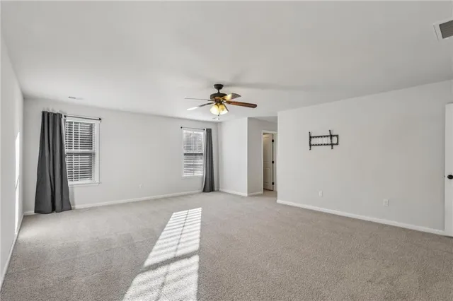 a view of a livingroom with a ceiling fan and window