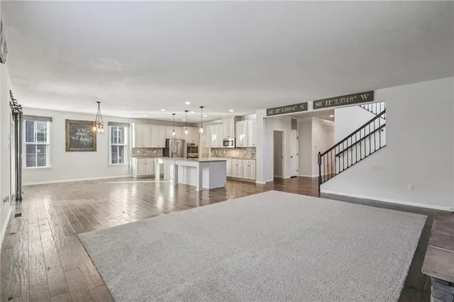 a view of a living room a kitchen with furniture and wooden floor